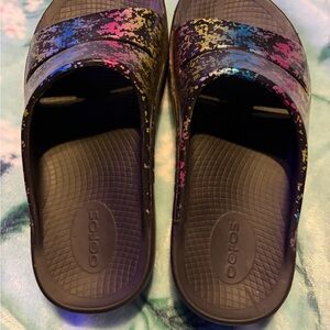 OOFOS Black Slide Sandals with Pink Blue and Gold Splatter